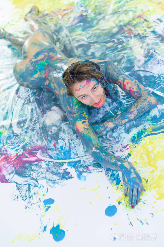 从一个裸体的女人的头顶上喷绘一个没穿衣服的女孩躺在一块有色斑和