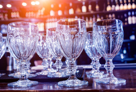 Wine and martini glasses in shelf above a bar rack in restaurant