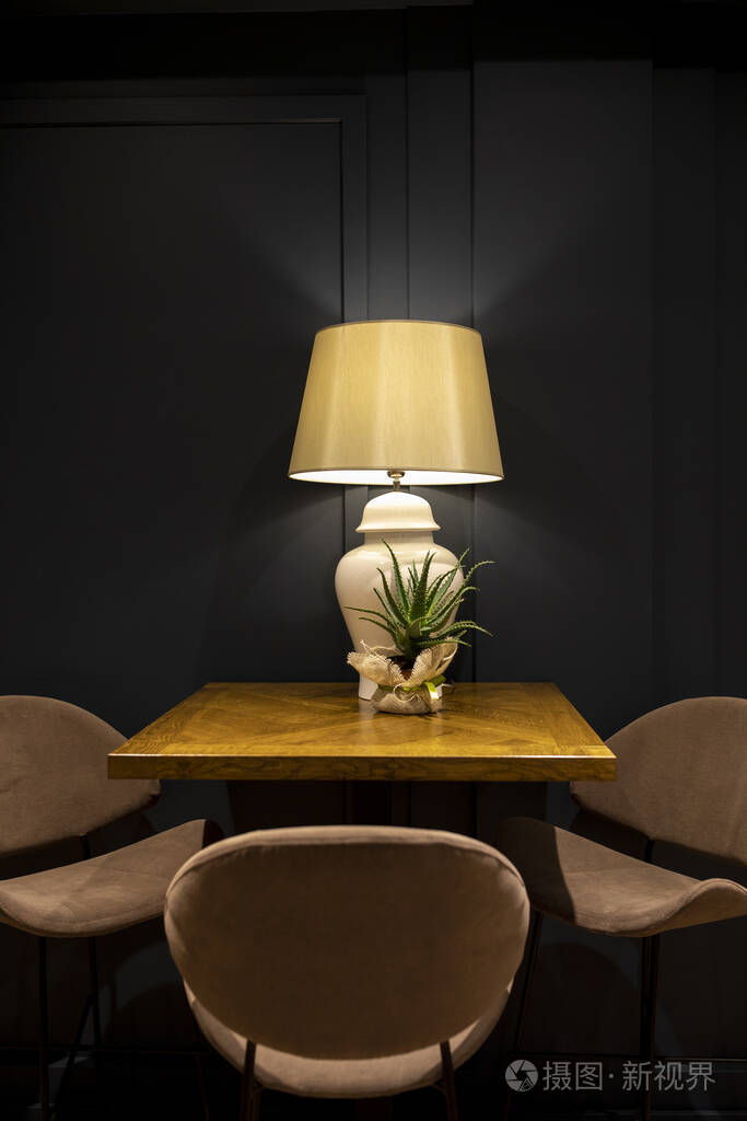 木制甲板上的台灯和小芦荟桌子旁边的椅子黑色背景
