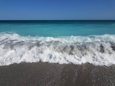 白浪和大海一起拍打在沙滩上图片
