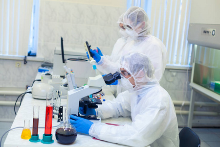 病毒知识科学家们穿着防护服在一个科学实验室里研究一种危险的病毒以