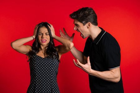 红底女在摄影棚里,年轻人情绪化地对着红底的妻子或女友尖叫.