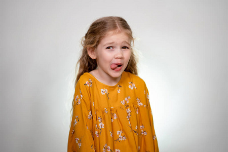 A little girl shows her tongue. 