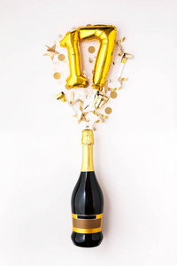 17周年纪念派对快乐。香槟酒瓶配金色气球。