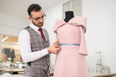 男裁缝用卷尺量衣服腰围照片