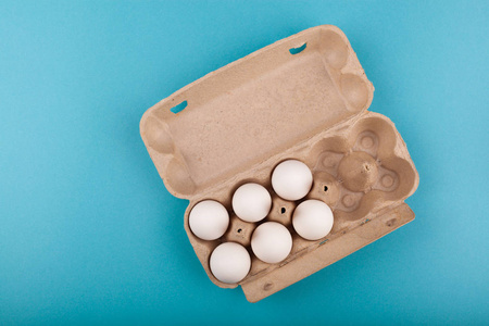 鸡蛋鸡蛋。打开的灰色盒子和白色鸡蛋的俯视图。被隔离在蓝色背景下。健康生活方式的概念，获取纯蛋白质。适当的早餐。六个鸡蛋。