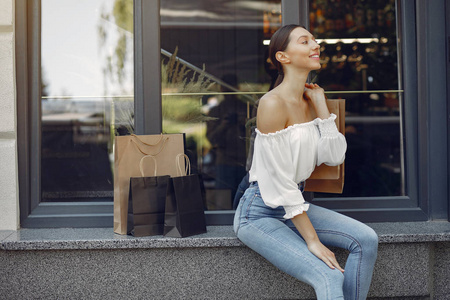 Elegant and stylish girls in a summer city with shopping bags