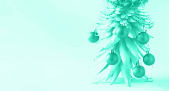 创意圣诞树由菠萝和圣诞饰品制成，背景为薄荷色，复制空间。贺卡，新年晚会的装饰。流行的绿色和绿松石色。横幅