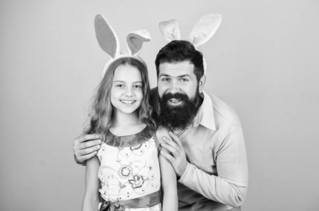 家里的爸爸和女儿都戴着兔子耳朵。父亲和孩子庆祝复活节。春节假期。复活节。儿童复活节活动。复活节快乐。假日兔子长耳朵。家庭传统观念