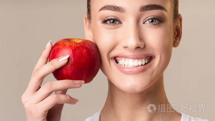 女孩抱着红苹果近脸微笑摄影棚拍摄全景