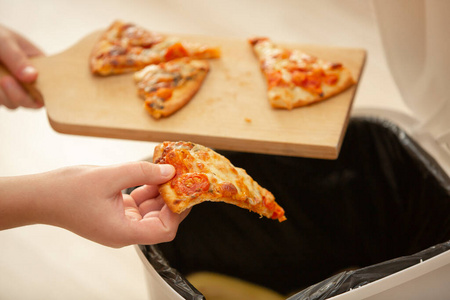 杜绝食物浪费,少妇将剩饭扔进垃圾桶,美食概念照片