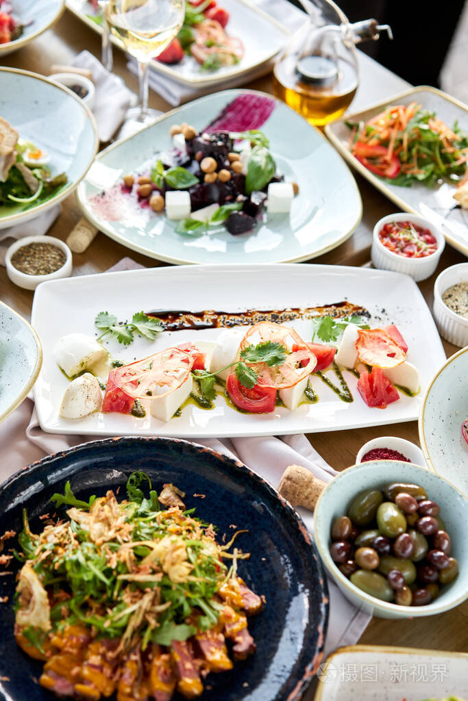 桌上摆着许多不同的美味佳肴桌子上摆着各种各样的零食餐厅菜单意大利