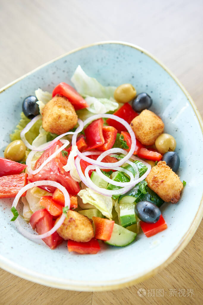 传统希腊沙拉配新鲜蔬菜菲塔奶酪和橄榄餐厅木桌