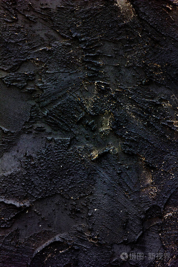 黑色的旧墙开裂的混凝土背景黑色装饰灰泥与金色飞溅