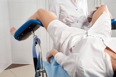 妇科医生检查坐在妇科手术椅上的病人的缩影全景图.女性健康观念.照片