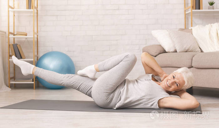运动型老年妇女在家做腹肌锻炼