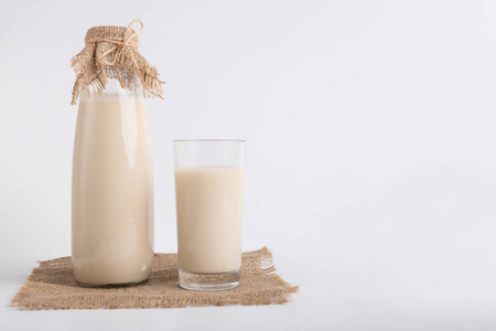 瓶装豆浆,玻璃在亚麻布上照片