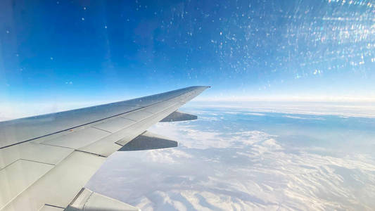 从平面上看风景从飞机的窗户上看。飞过云端的机翼