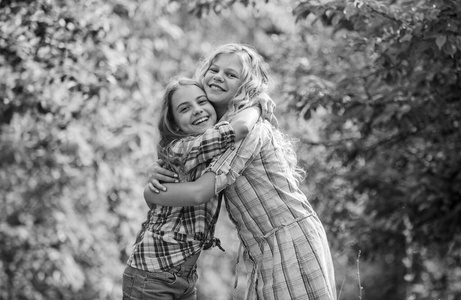 真正的友谊。女孩们笑脸相迎。女孩孩子最好的朋友拥抱。姐妹般的爱和支持。快乐的童年。拥抱和爱的概念。孩子们快乐在一起的自然背景