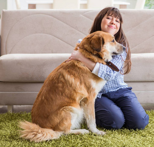 快乐的女主人和金毛猎犬在家照片