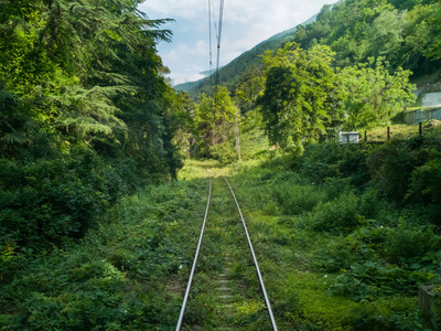 夏季的山区铁路，绿色植物消失在高加索的远处，在火车站