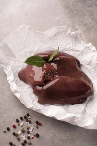 肝石生猪肝放在石头台面上的纸上.猪肉,杂碎.照片