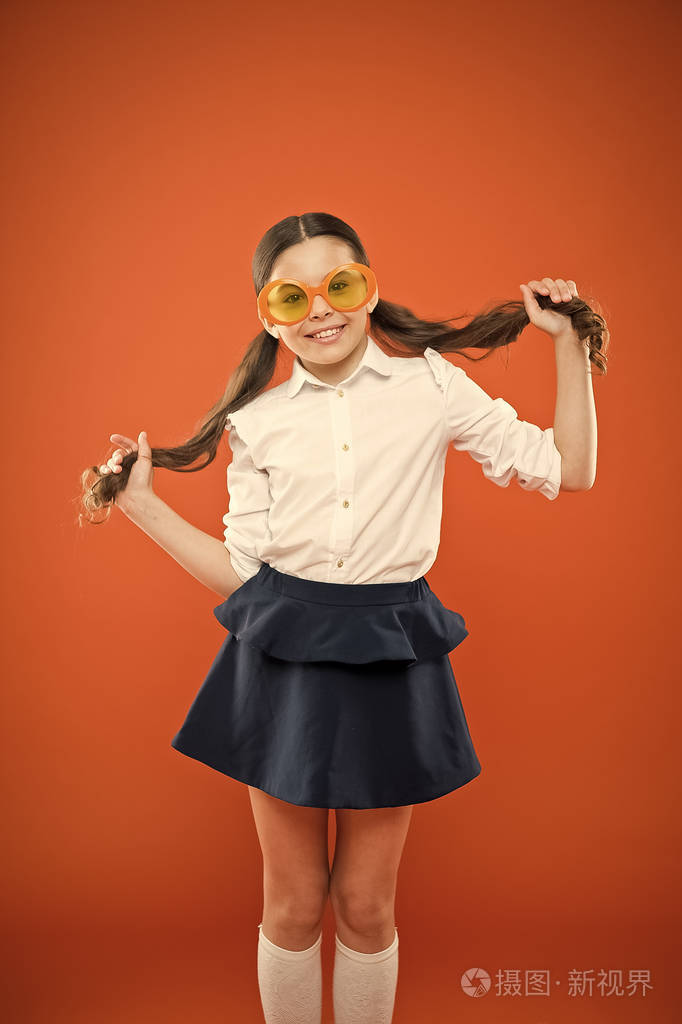 女学生可爱的马尾辫优秀的小学生概念女孩穿着橙色背景的校服学校教育