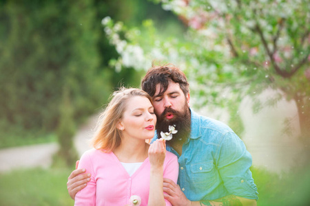 复活节夫妇，花树旁的年轻幸福夫妇。恋爱中的性感情侣。阳光明媚的春日里的情侣。