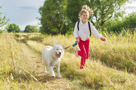 小女孩和白狗在草地上奔跑图片