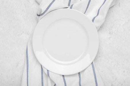 干净的石头干净的白色盘子在干净的毛巾上,条纹在石头光的极简主义