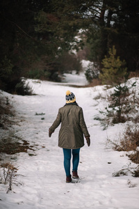 孤独的女人走在雪白的冬日路上