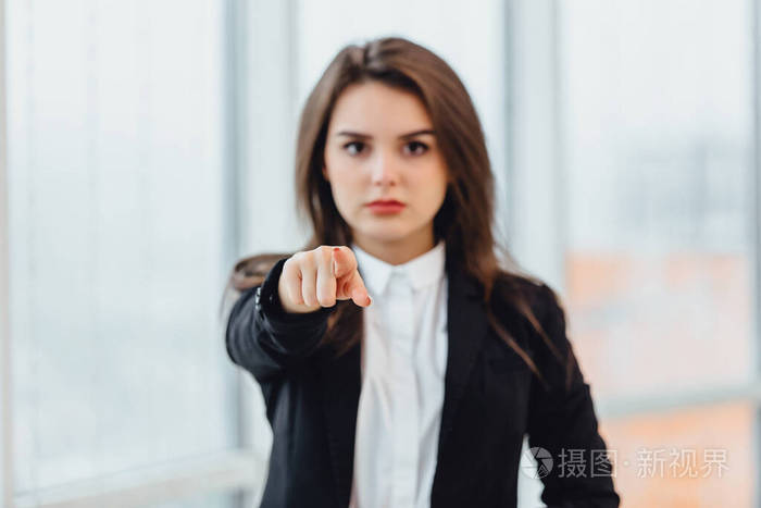 一个严肃的年轻女人的特写镜头，指着某人，好像在说你做错了什么，你的错。消极的人类情绪概念。