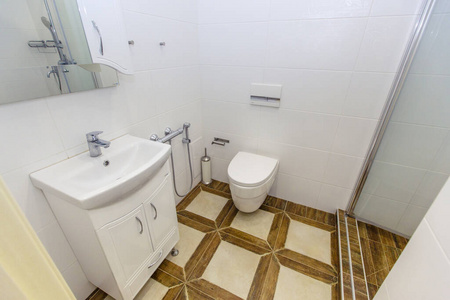 白色简约风格的浴室。明亮的白色瓷砖，浴室，卫生间，水槽，地板上的米色瓷砖。时尚时尚简约