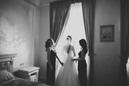 伴娘的手放在婚纱上。幸福的婚姻和新娘在婚礼日的概念