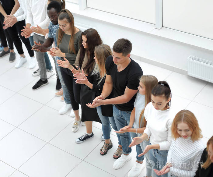 形形色色的年轻人站成一排指着一个复制的空间