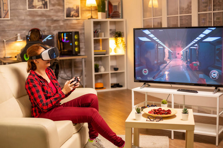 女性玩家在深夜使用虚拟现实耳机玩游戏