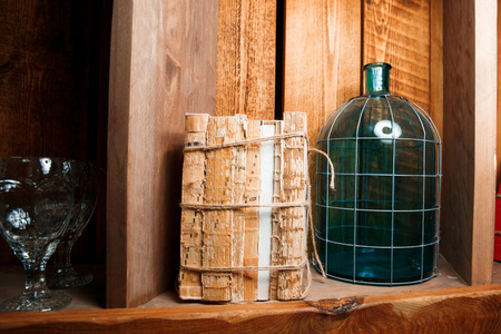 Old books, rewound with a rope, stand on a wooden shelf. 