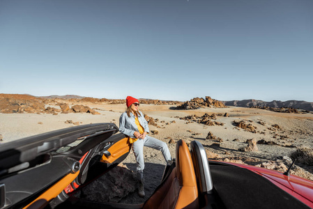 沙漠山谷中开敞篷车的女人图片