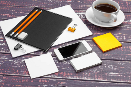 紫色桌子上的品牌文具模型。纸张名片便笺簿钢笔和咖啡的俯视图。