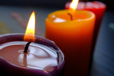 Close up of colorful burning candle at night 