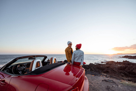 可爱的情侣,开车旅行展开双臂欢呼的年轻情侣海滩上的一对可爱的情侣