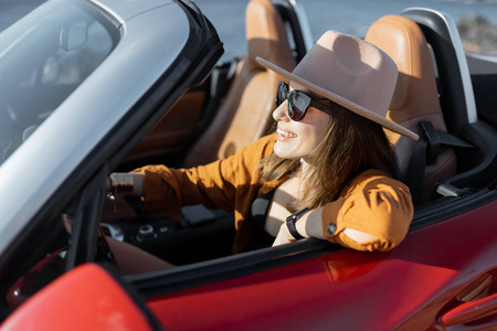 在海边开敞篷车的女人照片