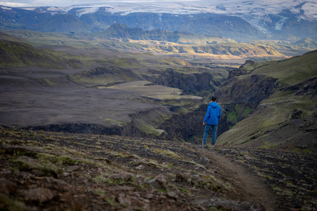 冰岛劳加维格尔赛道上，穿着夹克的高加索人站在雪山上。提倡健康的生活方式