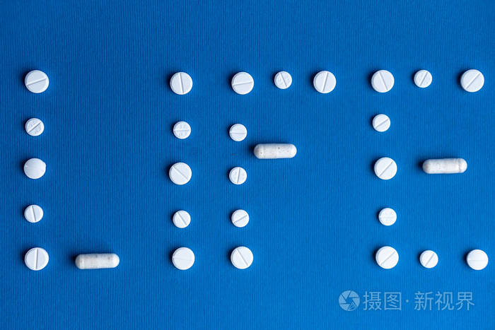 生命这个词由白色药丸和胶囊组成背景是经典的蓝色白色的药片和胶囊以