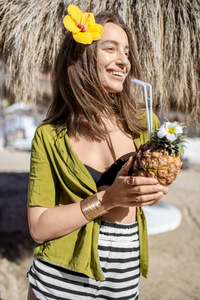 在海滩度假村喝着异国情调鸡尾酒的女人