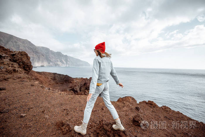 在岩石海岸旅行的女人