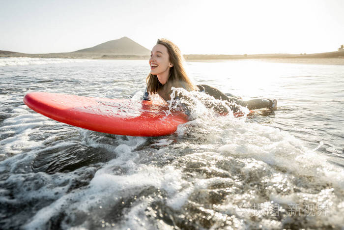 在冲浪板上游泳的女人