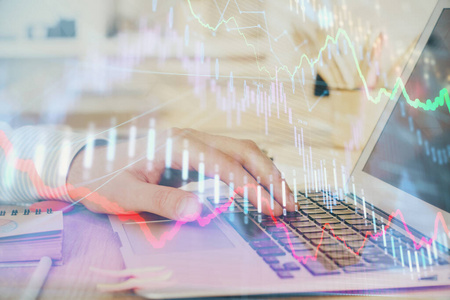 两次曝光股票市场图形，背景是人在笔记本电脑上工作。财务分析的概念。
