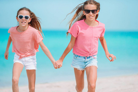快乐有趣的小女孩们在热带海滩玩得很开心。