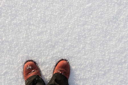 红色或棕色皮靴或雪地鞋在雪地上的俯视图,上面有复制空间.照片